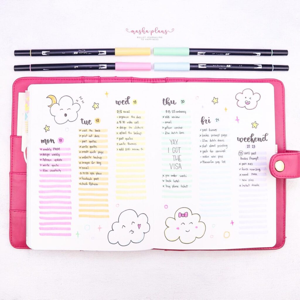 Colorful bullet journal spread with doodles of clouds and a pink planner cover.