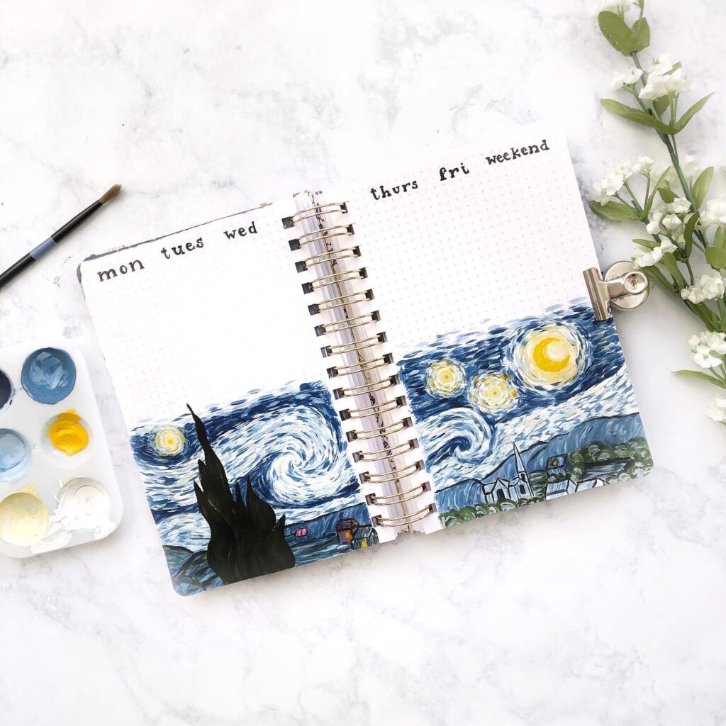 Open journal with Van Gogh-inspired art and weekly planner, paint palette nearby on marble surface.