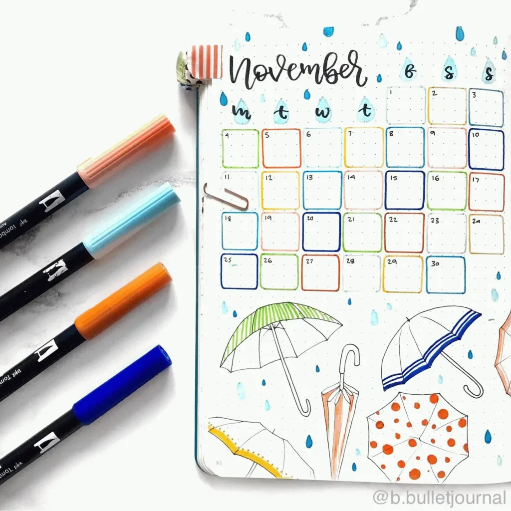 November bullet journal spread with colorful pens and umbrella doodles design.