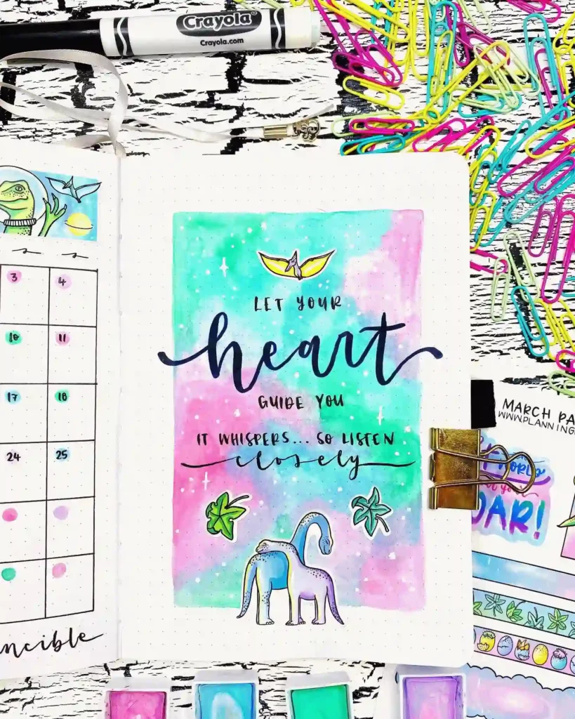 Colorful journal page with motivational quote, pastel watercolor art, calendar, and paper clips.