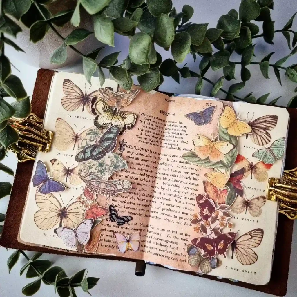 Open book adorned with colorful butterfly illustrations surrounded by green foliage, showcasing artistic literature decor.