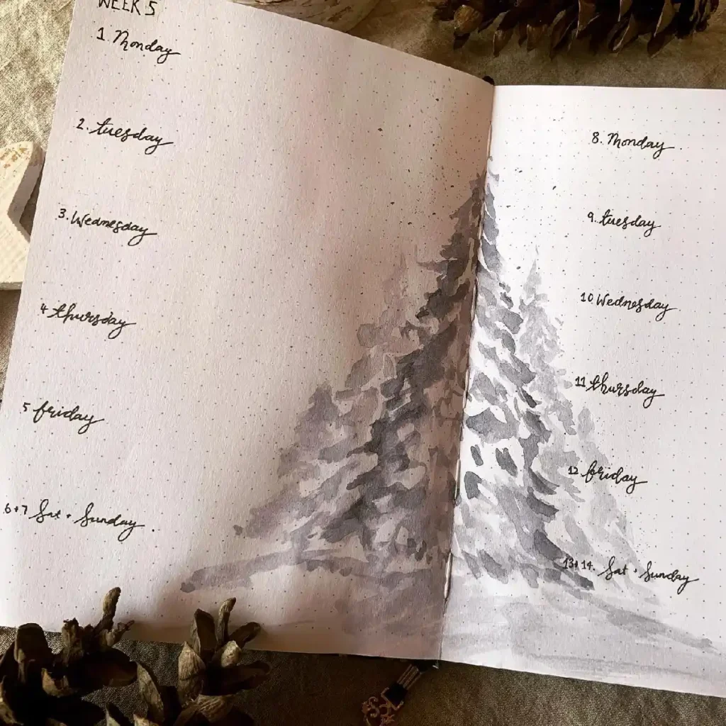 Open bullet journal spread with watercolor trees, showcasing a weekly planner layout for organized scheduling.