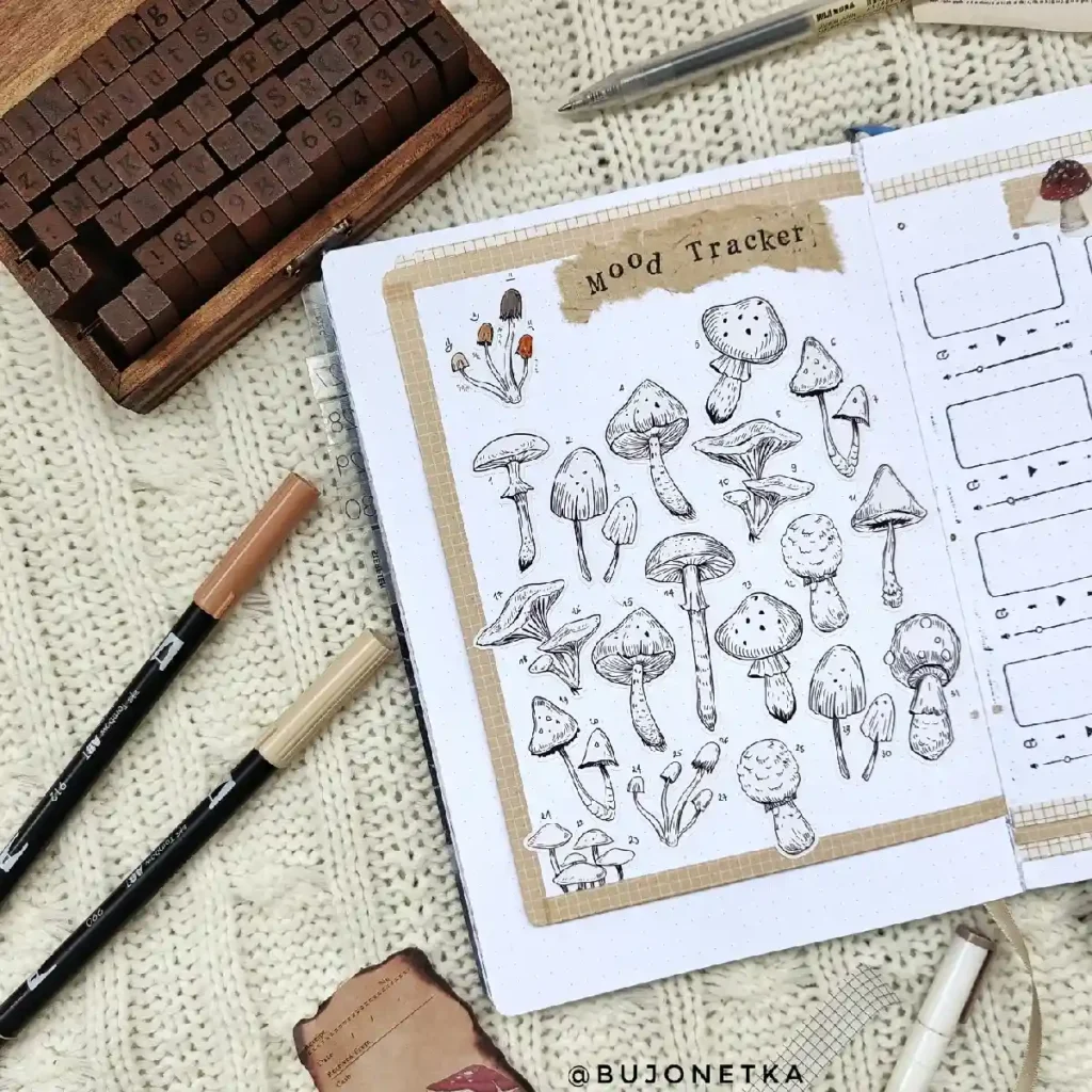 Artistic bullet journal layout featuring a whimsical mood tracker with various mushroom illustrations and stationery tools.