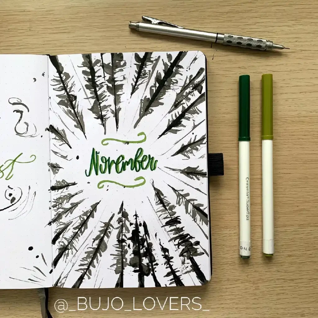 Bullet journal spread for November featuring artistic tree designs and green calligraphy on a wooden background.