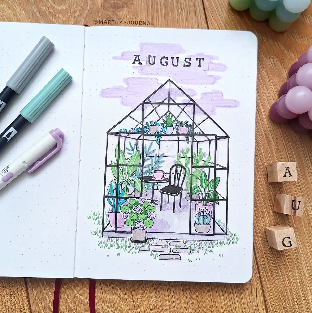 Colorful bullet journal page for August featuring a whimsical greenhouse filled with plants and a cozy chair.
