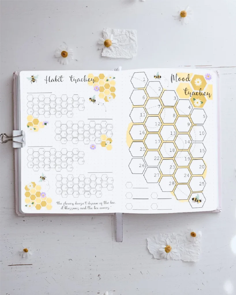 Alt text: Aesthetic bullet journal page featuring a habit tracker and mood tracker with honeycomb designs and floral accents.