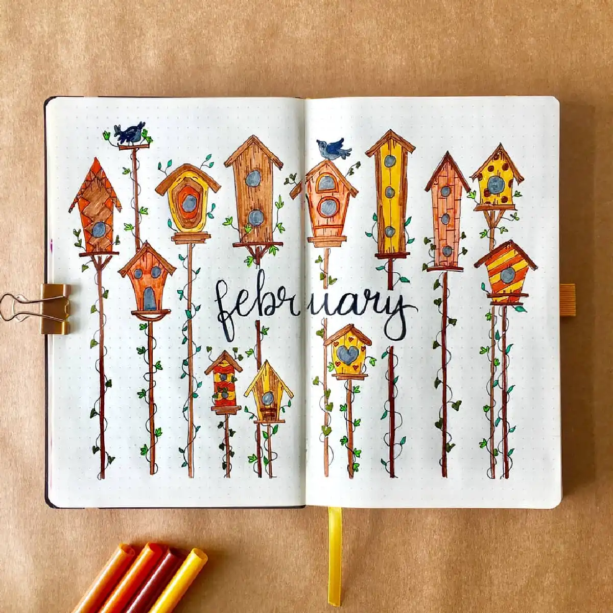 Colorful birdhouses and vines in a February-themed bullet journal spread, showcasing creative doodle art.