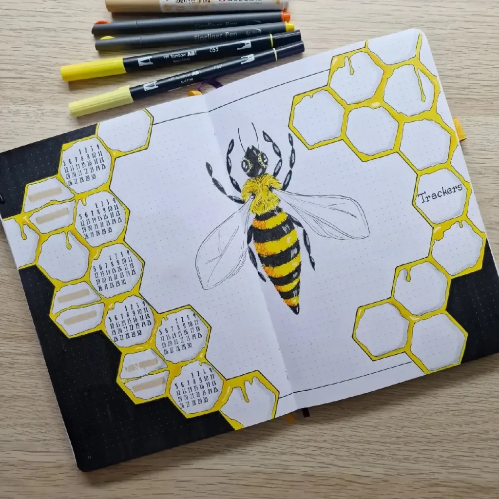 Illustration of a bee with honeycomb designs in a bullet journal, showcasing vibrant colors and a calendar layout.